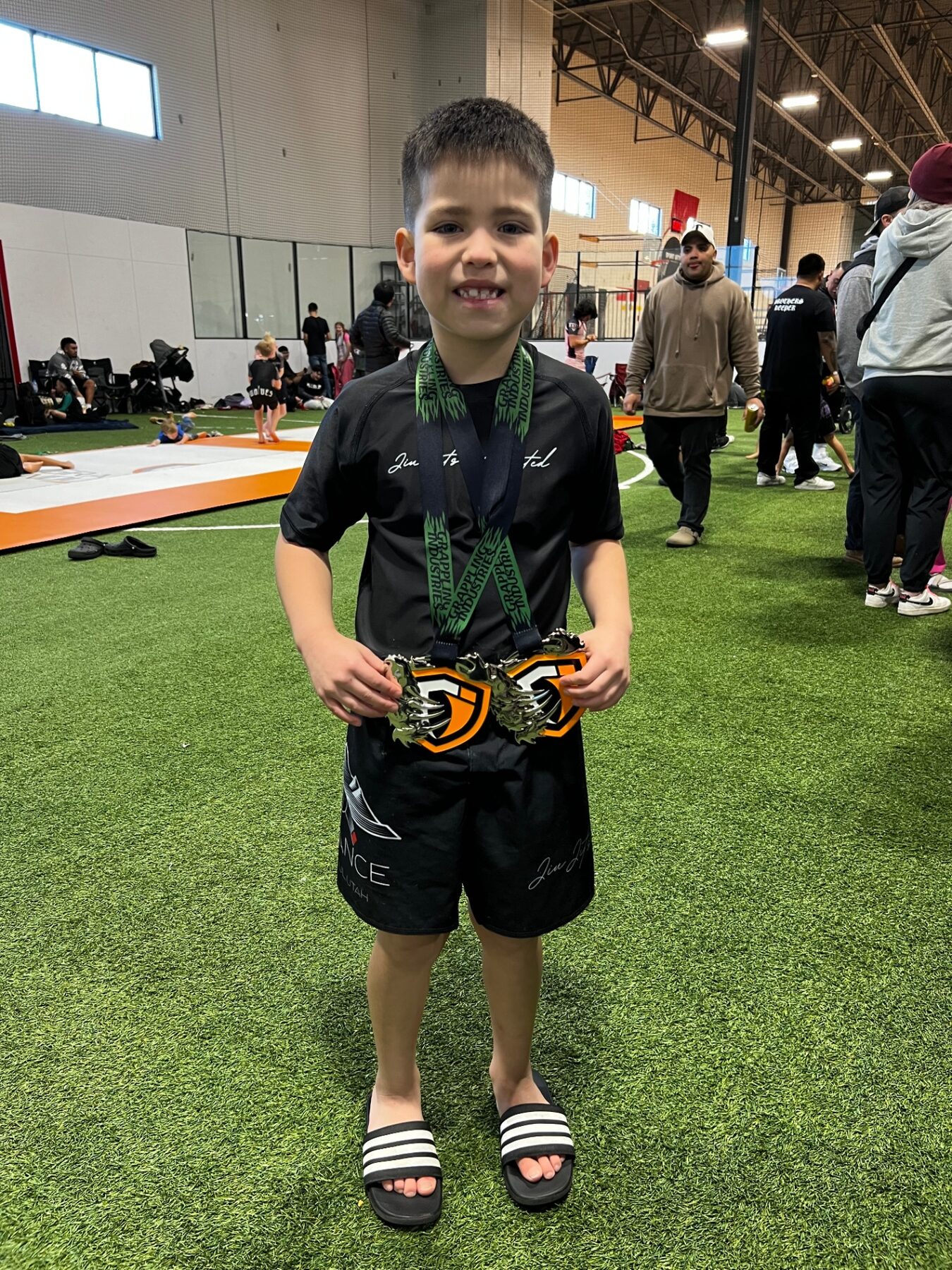 Oliver proudly holding his medals after a jiu-jitsu competition.